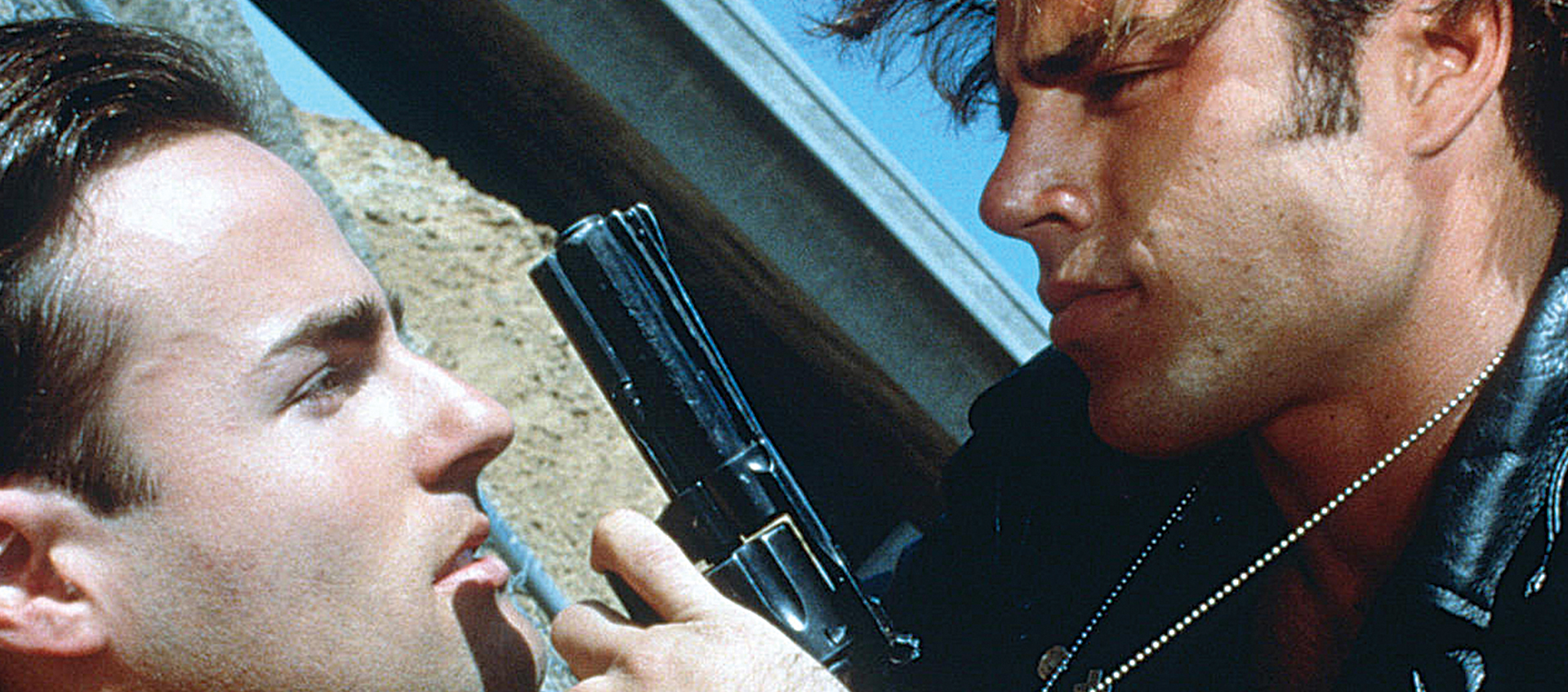 Actor Mike Dytri as Luke brandishes a gun in front of Craig Gilmore, playing Jon, in a scene from Gregg Araki's groundbreaking 1992 LGBTQ film The Living End